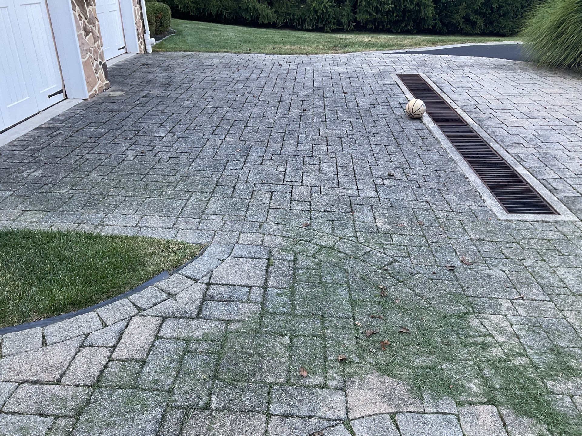 A Brick Driveway With A Round Object On The Ground