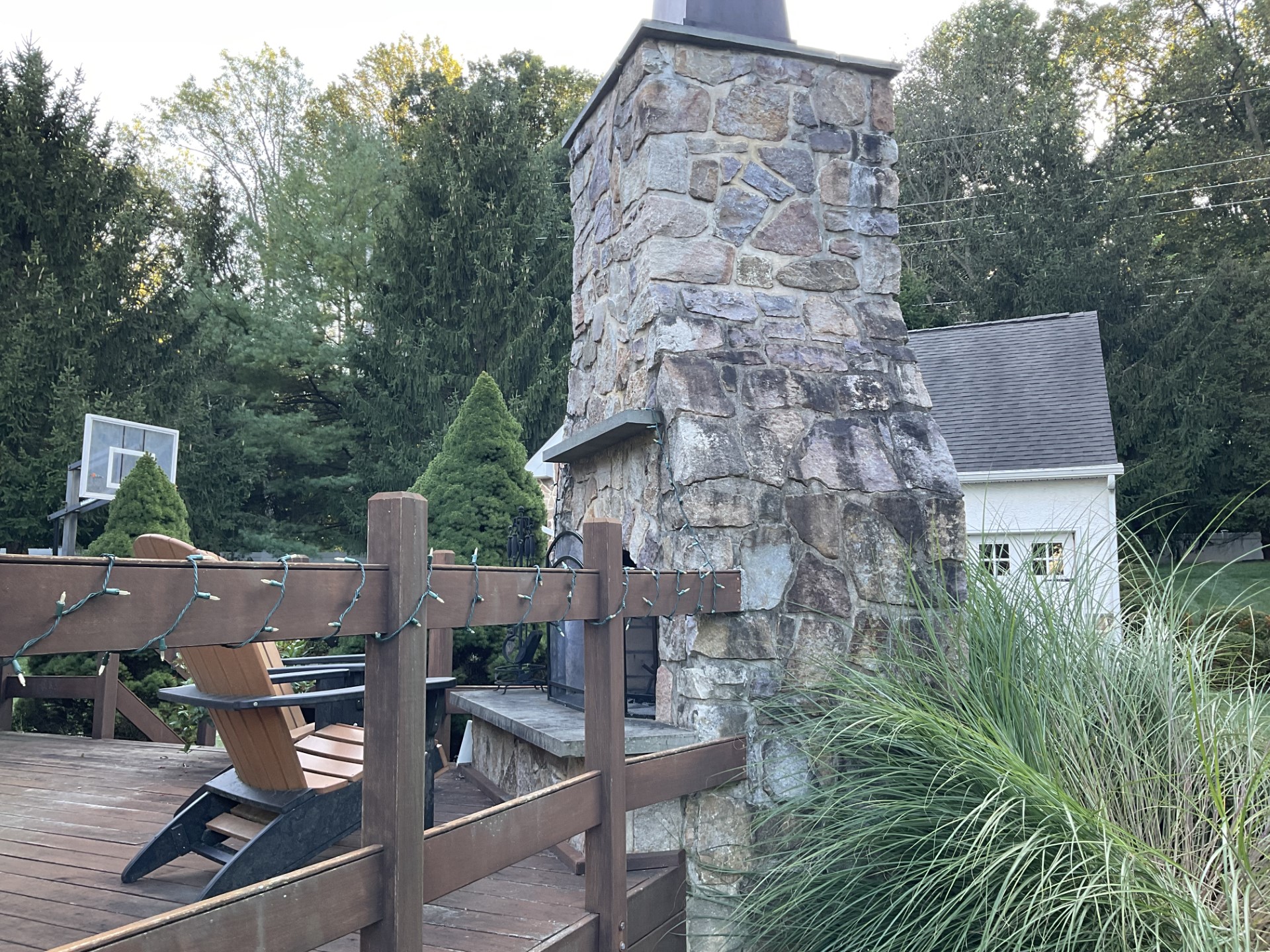 A Stone Chimney With A Wood Deck And A Wood Deck And A Wood Fence